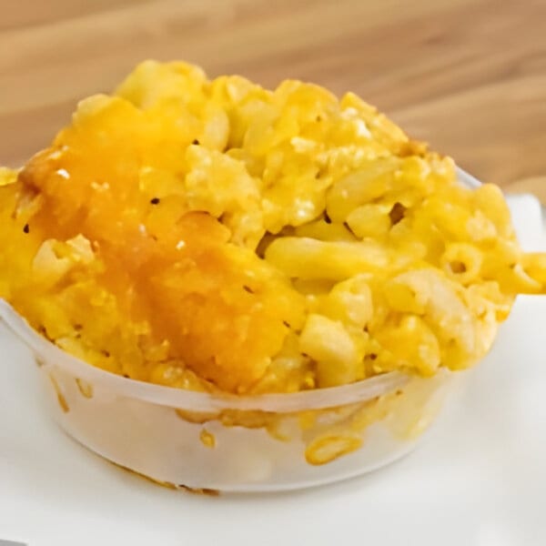 A close-up of Dad's BBQ creamy mac and cheese in a clear plastic container.